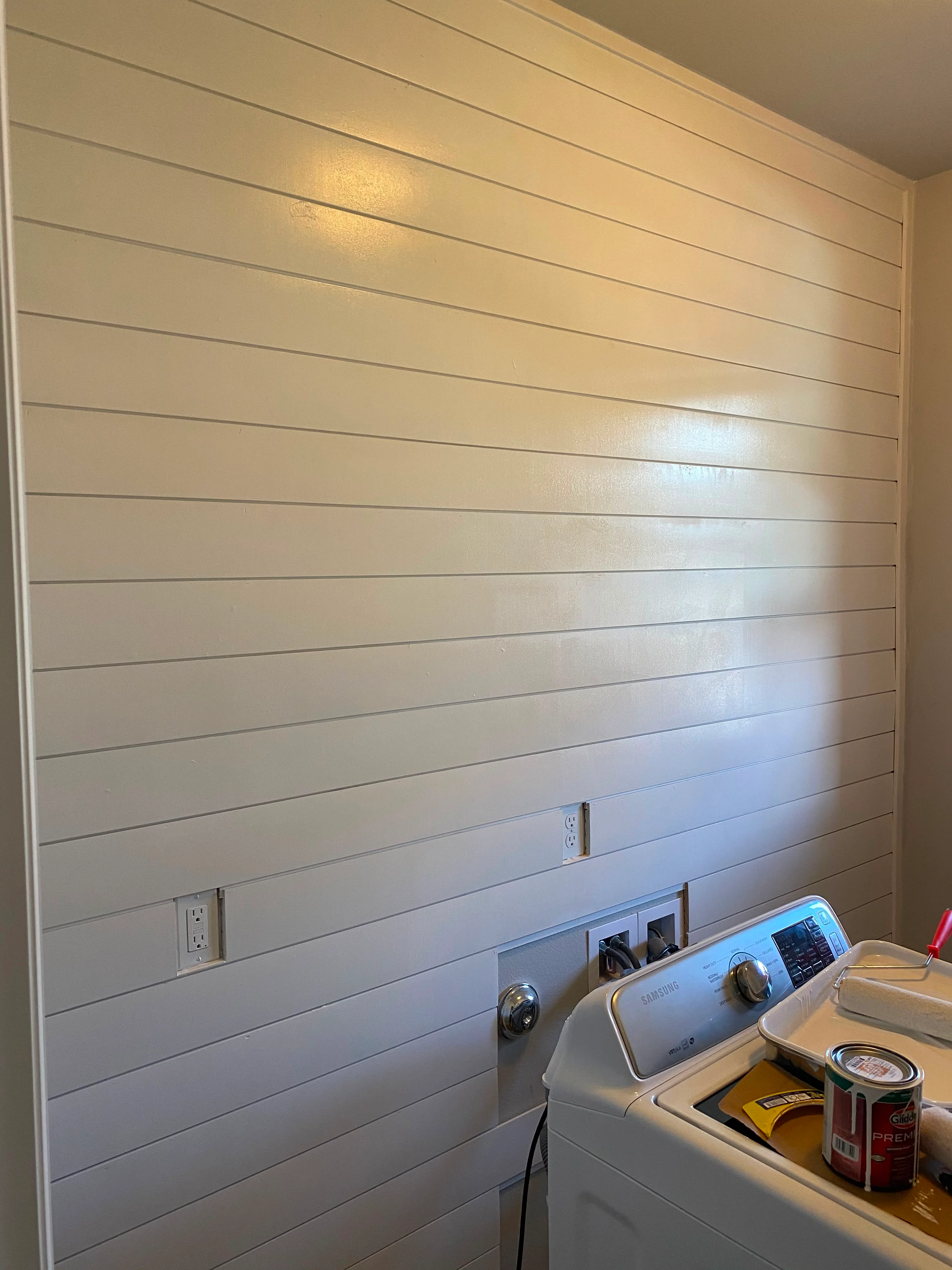 Horizontal white shiplap wall with integrated electrical outlets and switches
