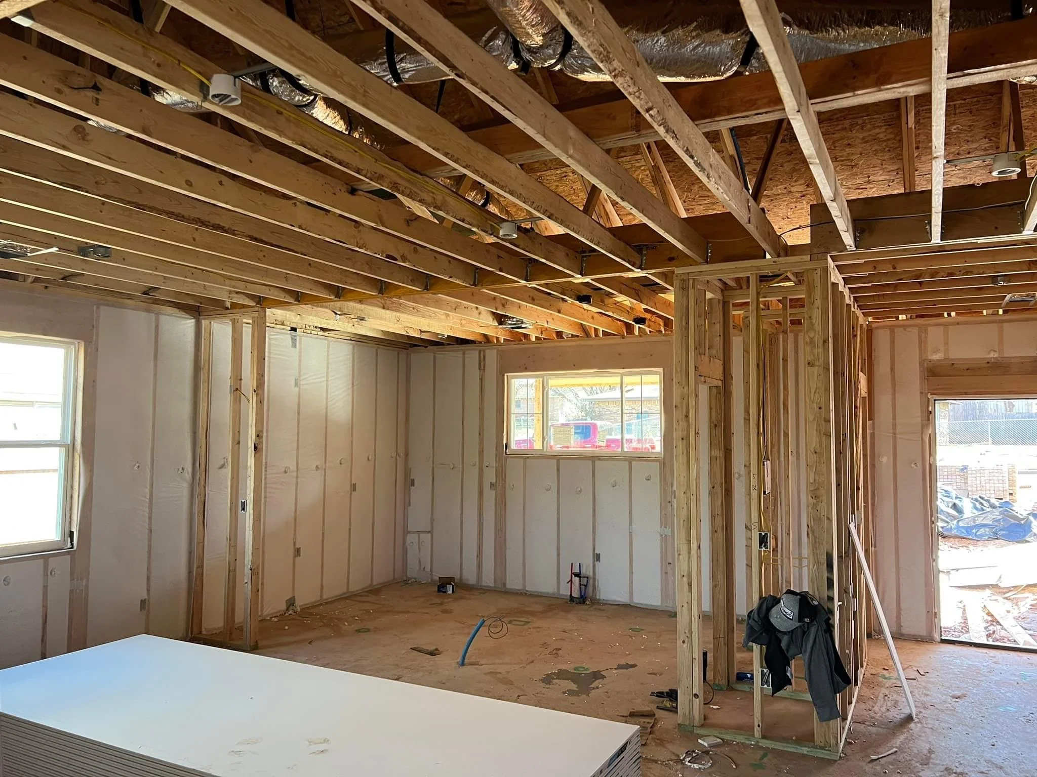 Interior framing with wood studs, drywall, exposed joists, and HVAC ductwork in progress
